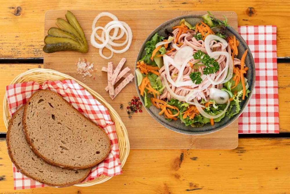 Wurstsalat mit Bauernbrot, Gurken und Zwiebelringen