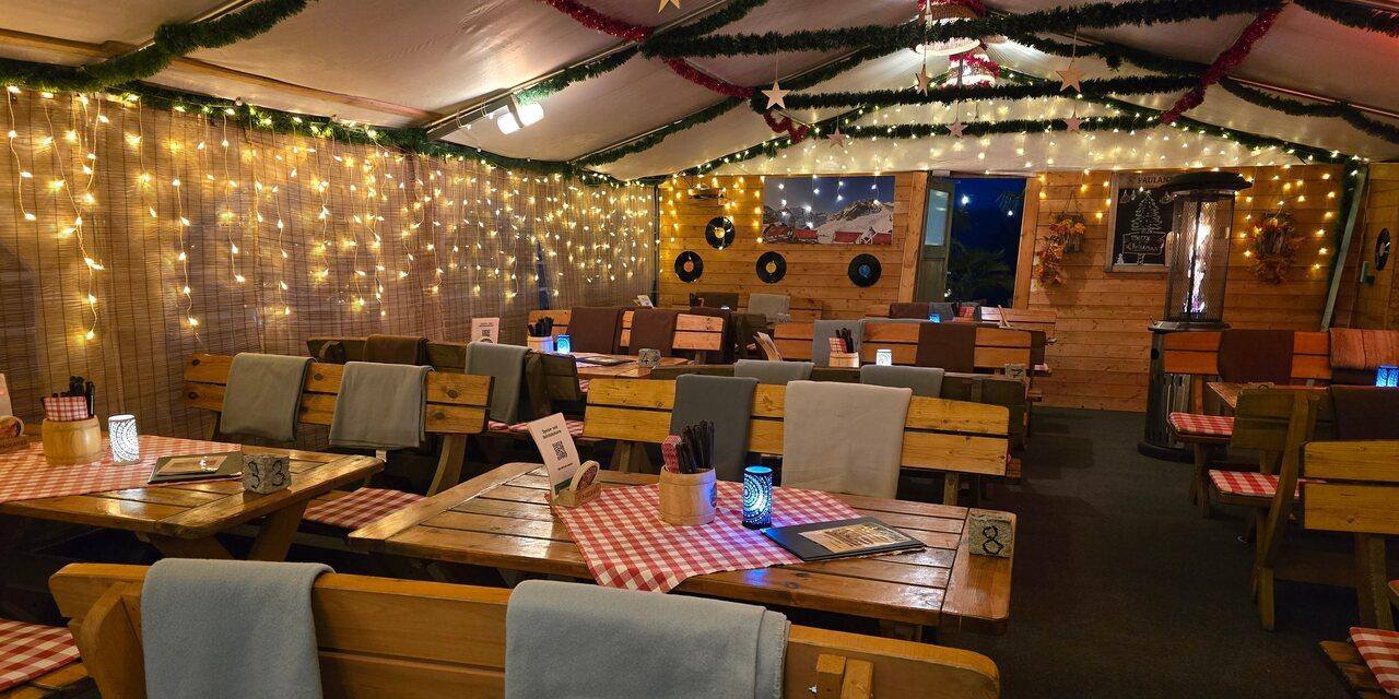 Feuerschale und Lichterketten im winterlichen Biergarten