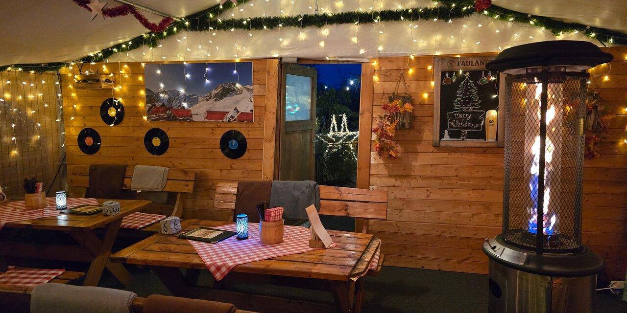 Die Schnitzel-Hütte im Lichterschmuck an einem Winterabend
